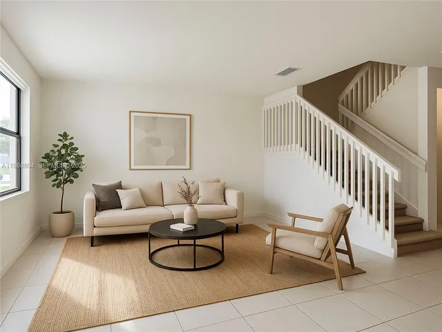 a living room with furniture and a potted plant