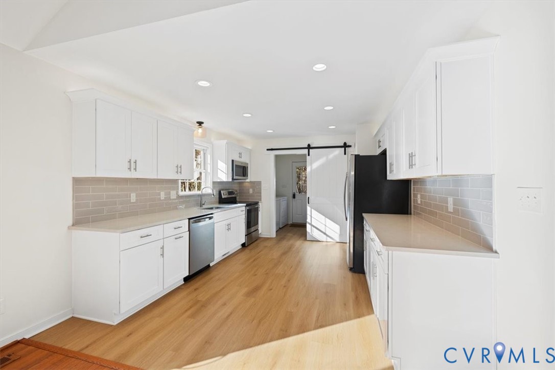 4255 Pierce Road Powhatan, VA 23139 - Photo 13 of 34 Kitchen with a barn door, white cabinets, applianc
