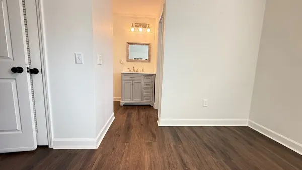 a view of a hallway with wooden floor and closet