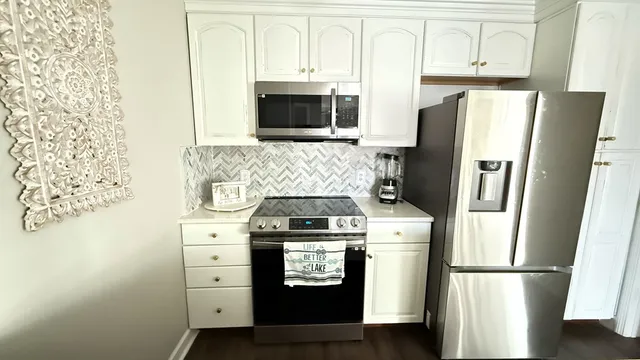 a kitchen with stainless steel appliances a refrigerator stove and microwave