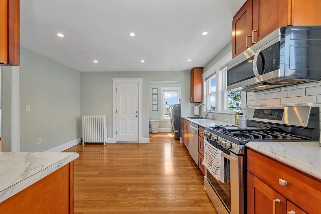 9-11 Locust Street, Unit 2 Winthrop, MA 02152 - Photo 11 of 41 a large kitchen with stainless steel appliances granite countertop a stove a sink and a microwave