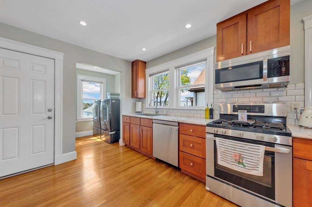 9-11 Locust Street, Unit 2 Winthrop, MA 02152 - Photo 12 of 41 a large kitchen with stainless steel appliances granite countertop a stove and a wooden floors