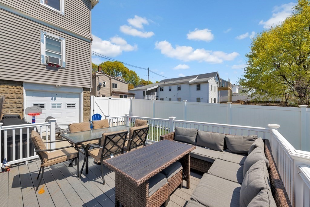 9-11 Locust Street, Unit 2 Winthrop, MA 02152 - Photo 27 of 41 a roof deck with a dining table and chairs with wooden floor