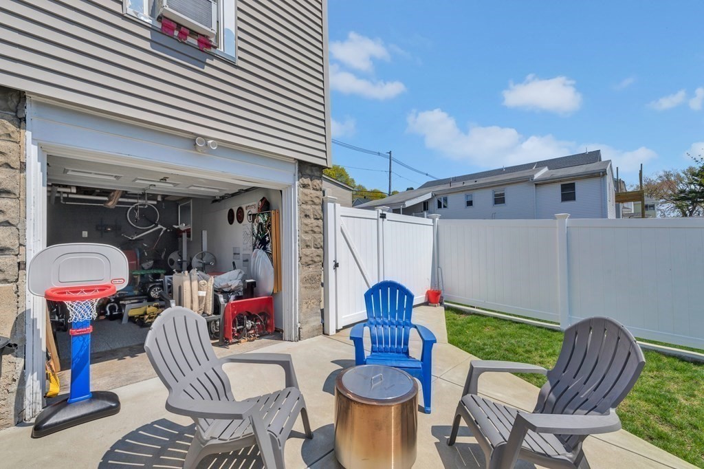 9-11 Locust Street, Unit 2 Winthrop, MA 02152 - Photo 30 of 41 a view of a patio with table and chairs with wooden floor and fence