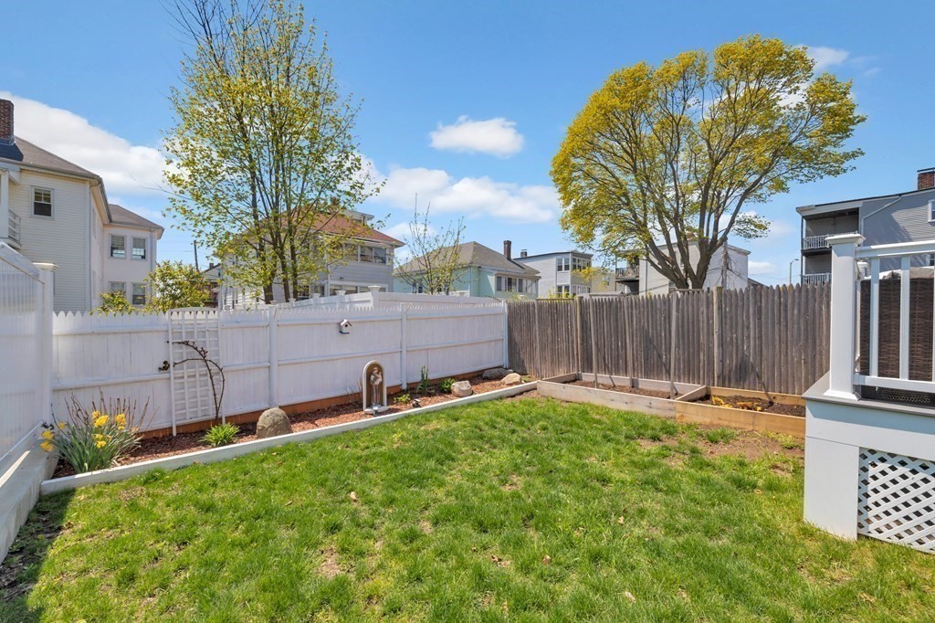 9-11 Locust Street, Unit 2 Winthrop, MA 02152 - Photo 34 of 41 a backyard with a table and chairs and wooden fence