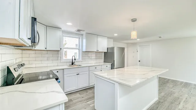 a kitchen that has a sink and a stove in it