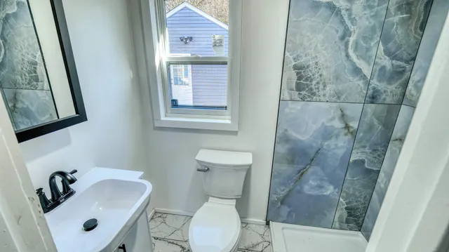 a bathroom with a sink and mirror with toilet