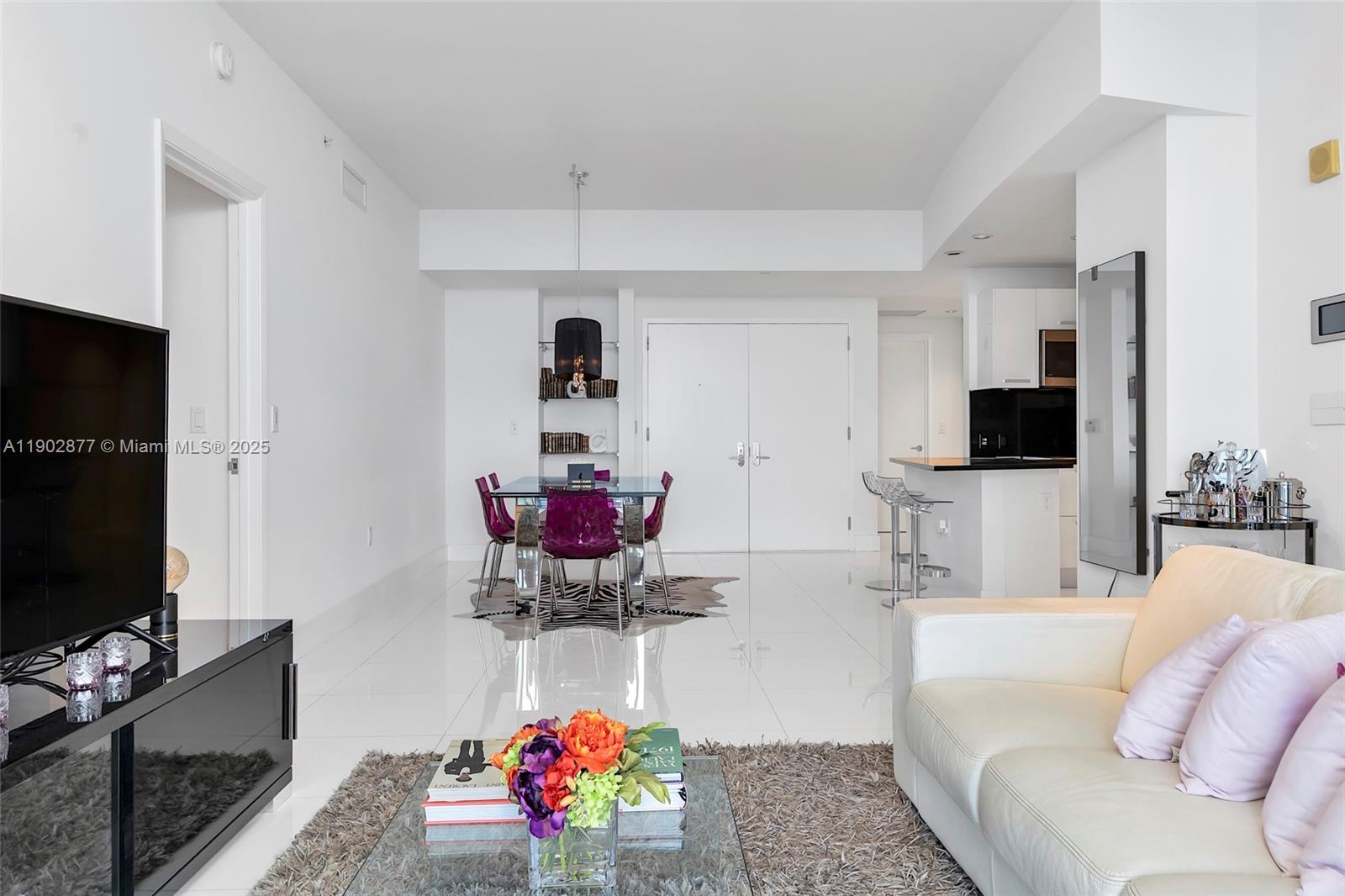 17121 Collins Avenue, Unit 2906 Sunny Isles Beach, FL 33160 - Photo 17 of 42 a living room with furniture and a flat screen tv