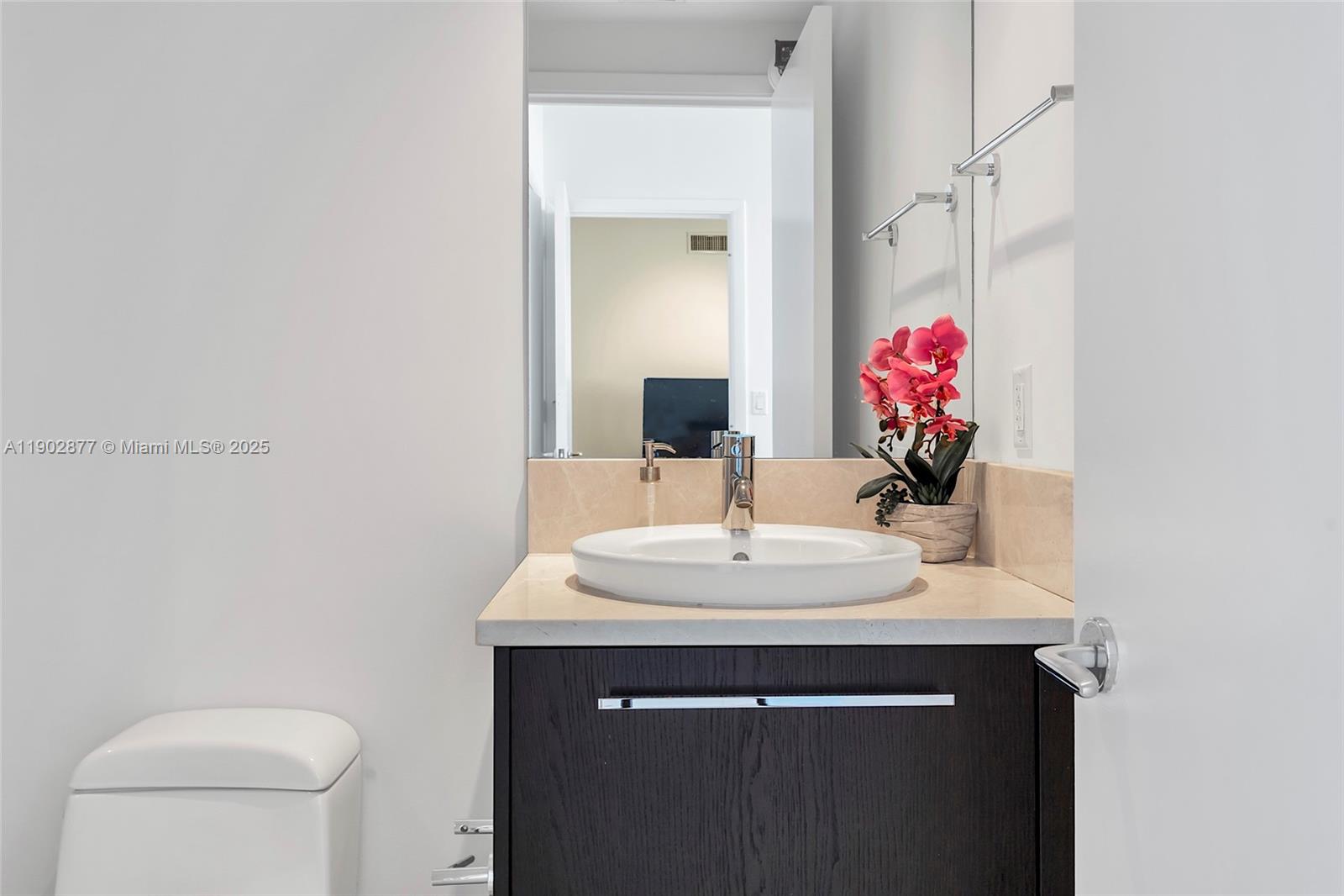 17121 Collins Avenue, Unit 2906 Sunny Isles Beach, FL 33160 - Photo 30 of 42 a bathroom with a sink vanity mirror and toilet