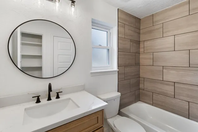 a bathroom with a sink a toilet and a mirror