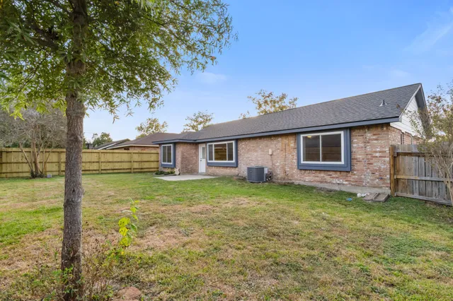 a view of a yard in front of a house with large tree