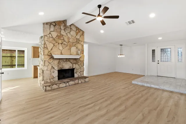 a view of empty room with fireplace and wooden floor