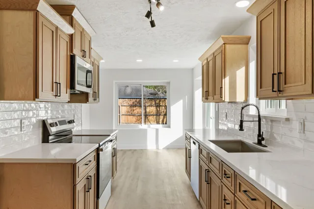 a kitchen with a sink a stove and cabinets