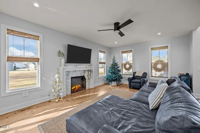a living room with furniture a fireplace and a flat screen tv