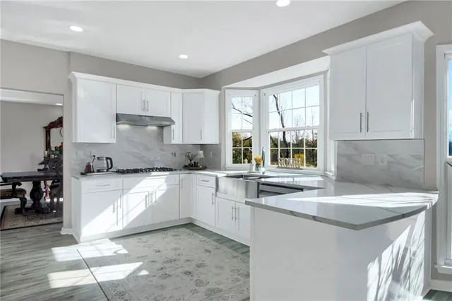 a kitchen with white cabinets and stainless steel appliances