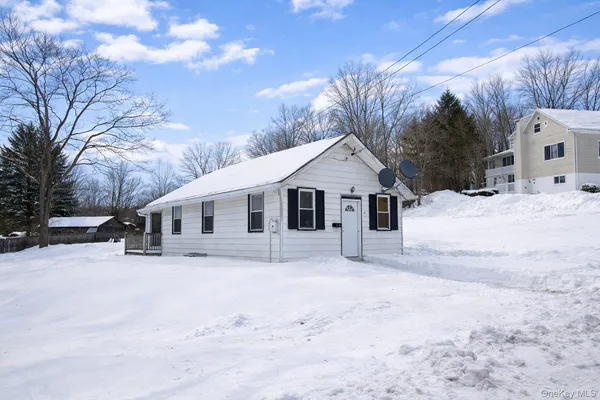 a front view of a house with a yard covered in snow