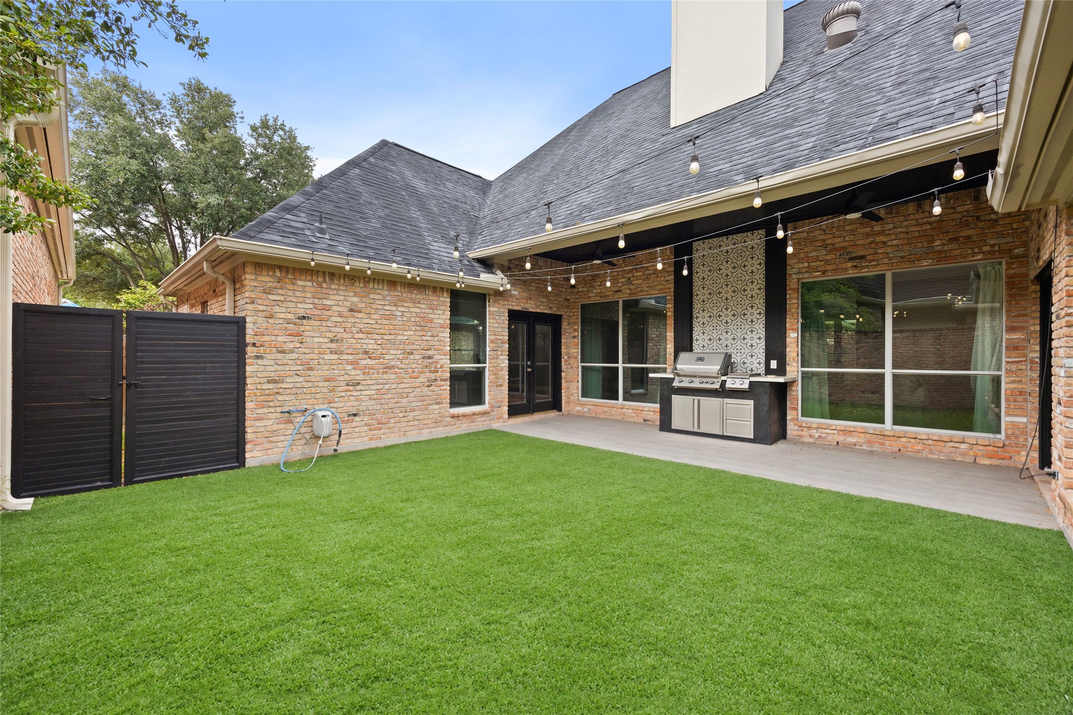 6239 Agassi Ace Court Spring, TX 77379 - Photo 19 of 19 Lovely courtyard backyard with lighting, built in gas grill. Artificial grass for minimal yard work!