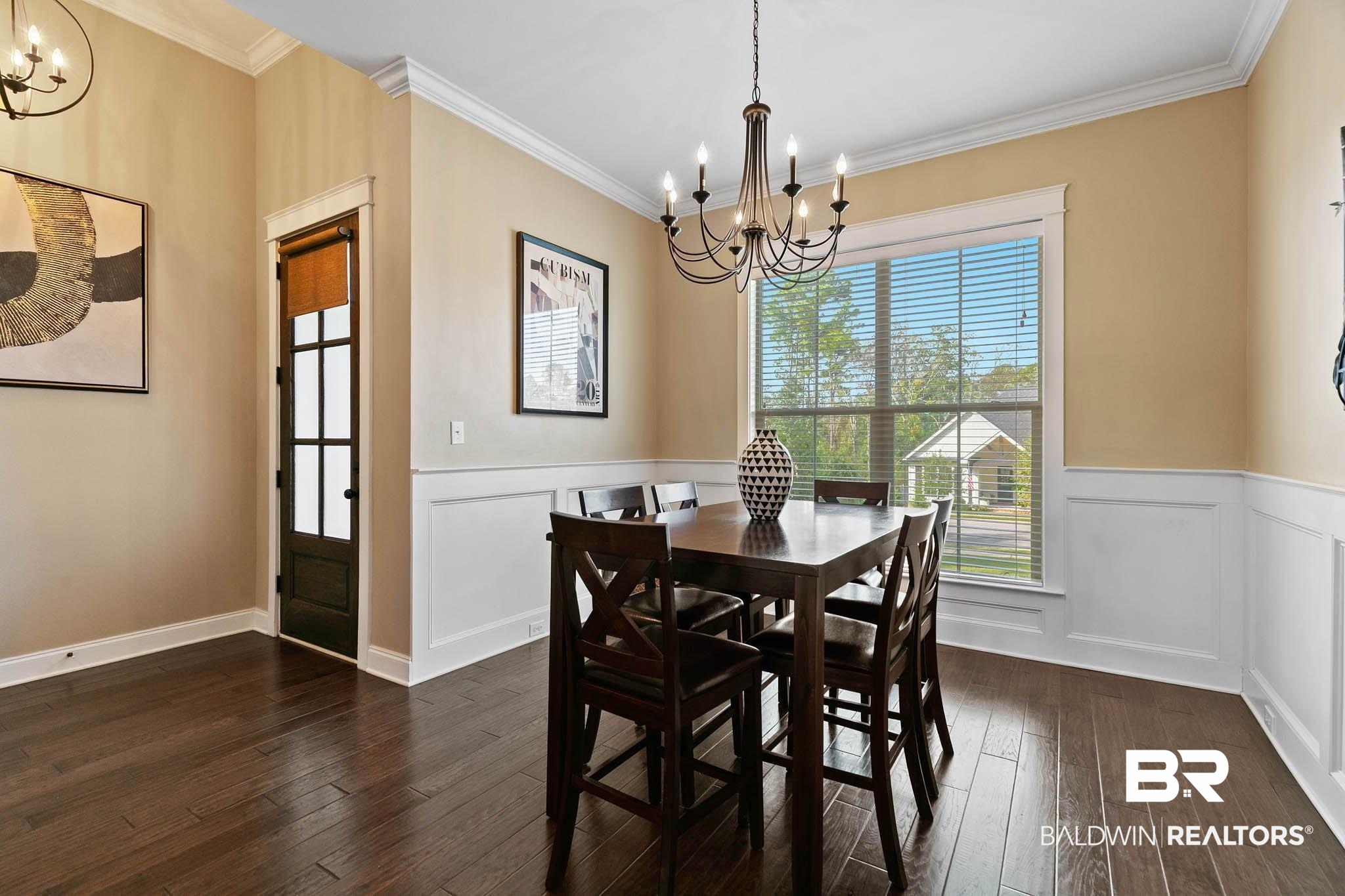 19740 Bunker Loop Fairhope, AL 36532 - Photo 8 of 33 Dining space with a chandelier, ornamental molding, dark wood-type flooring, and wainscoting