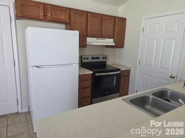 a kitchen with a refrigerator sink and cabinets