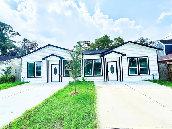 a front view of a house with a yard and potted plants