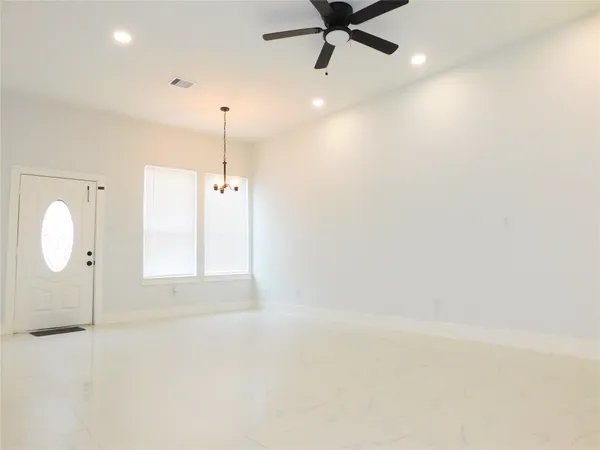 an empty room with a window and a ceiling fan