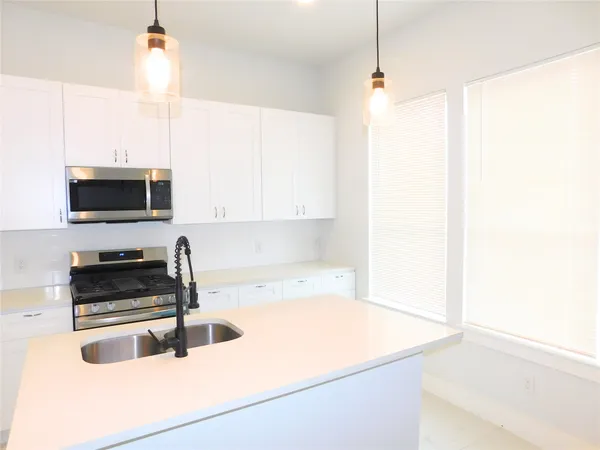 a kitchen with a sink a microwave and cabinets