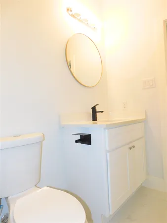 a bathroom with a toilet a sink and mirror