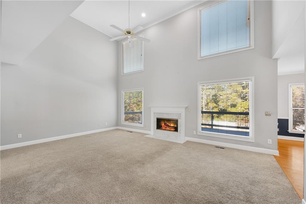 161 Brook Lane Roswell, GA 30075 - Photo 15 of 66 an empty room with windows fireplace and fans