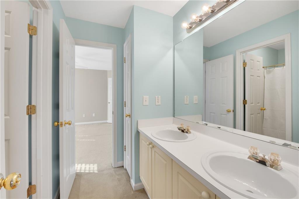 161 Brook Lane Roswell, GA 30075 - Photo 35 of 66 a bathroom with a sink a mirror and a shower