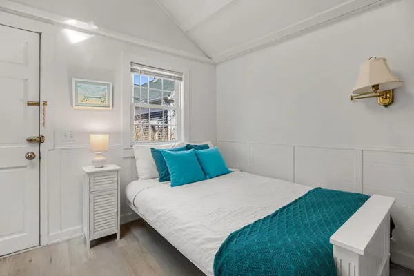 a bedroom with a bed dresser and a window