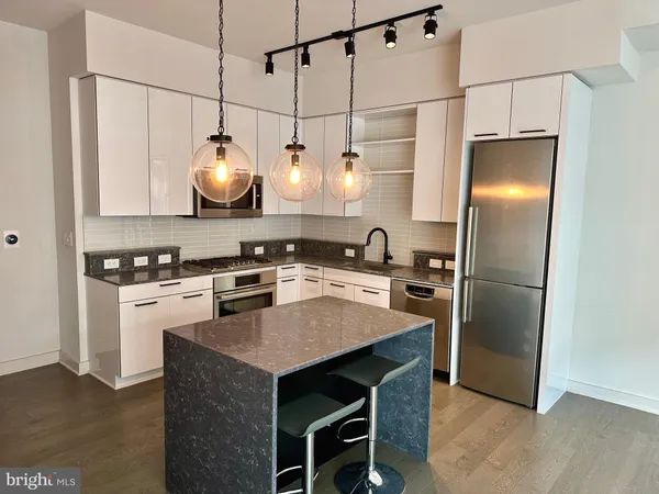 a kitchen with stainless steel appliances granite countertop a sink a stove a refrigerator and island