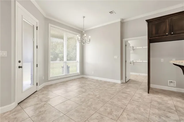a view of an empty room with cabinet and a bathroom