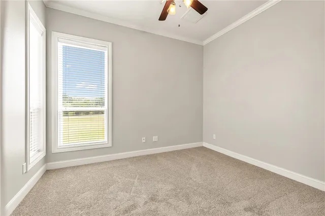 an empty room with a window and a ceiling fan