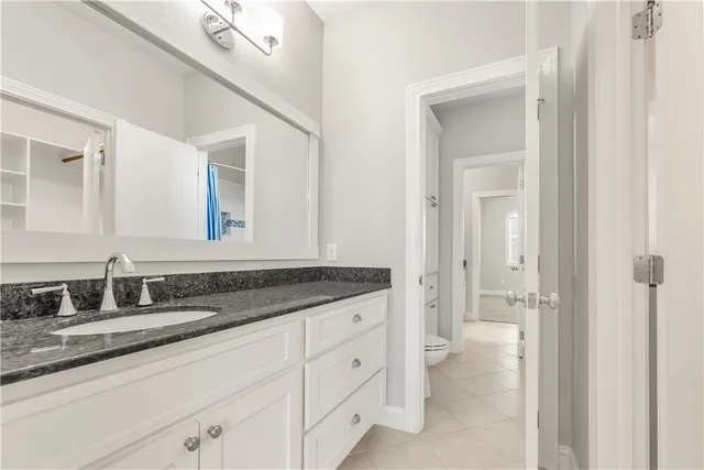 a bathroom with a granite countertop sink two mirror and a