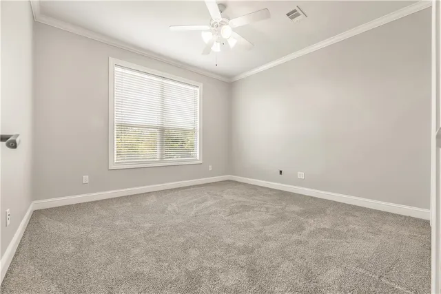 an empty room with a window and a ceiling fan