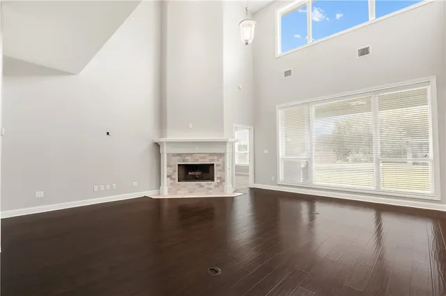a view of empty room with wooden floor and fireplace