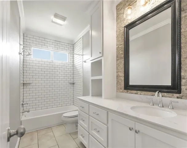 a bathroom with a granite countertop toilet a sink a mirror and shower