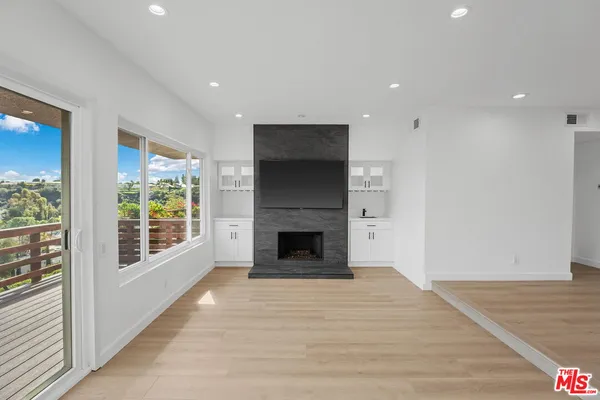 a view of an empty room with a window and fireplace