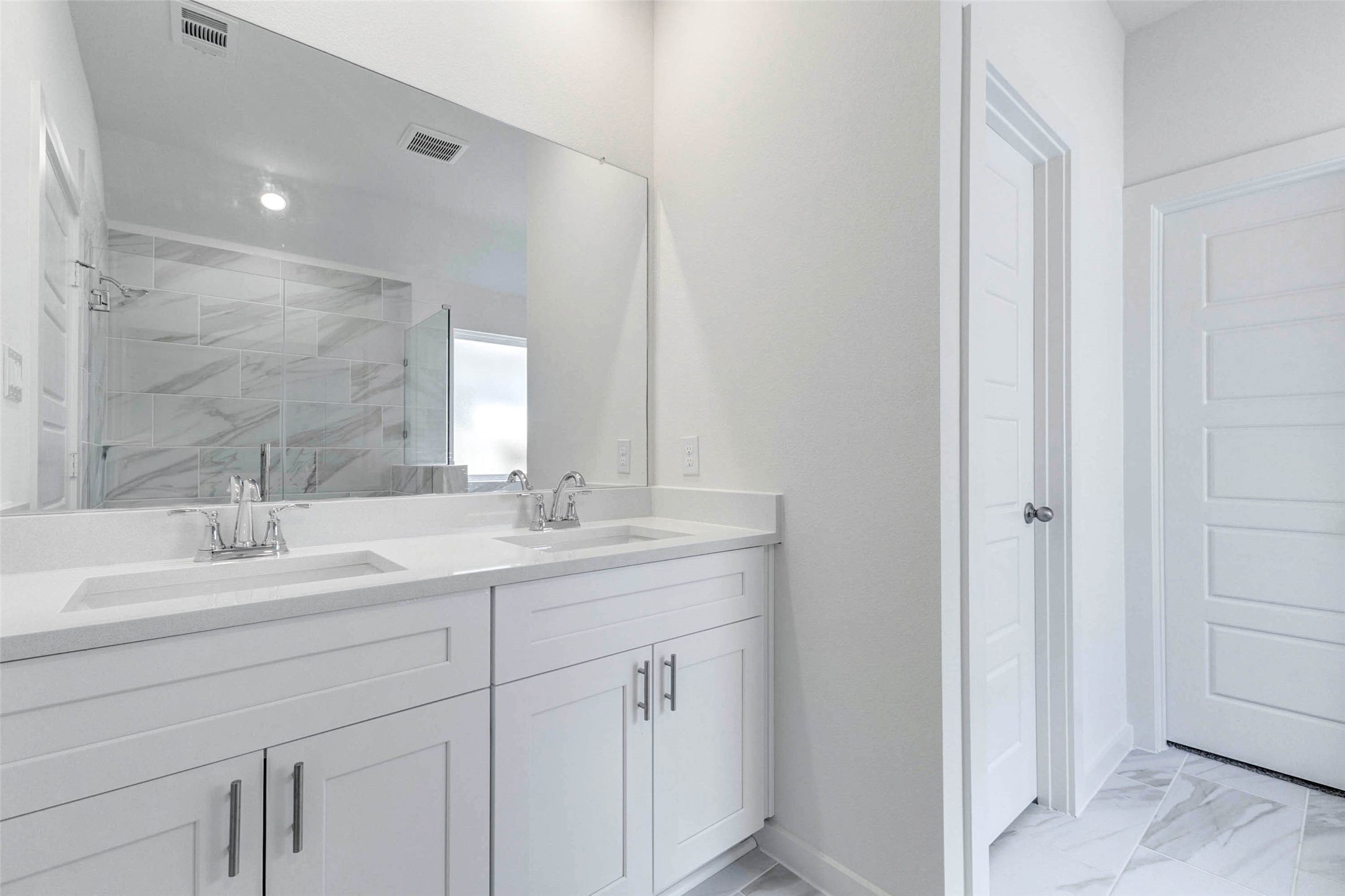 6463 Escondido Drive Rosharon, TX 77583 - Photo 23 of 30 Primary bath vanity with dual sinks, white cabinetry, chrome fixtures, large mirror, and access to the private bath areas. The neutral finishes and thoughtful layout offer both function and style for everyday routines.