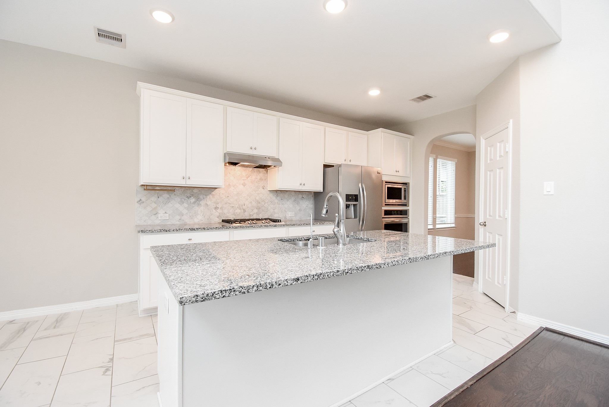6307 Grand Drift Court Katy, TX 77494 - Photo 14 of 49 Kitchen with granite counter top, gas stove, tile backsplash, and tile flooring. Refrigerator included.