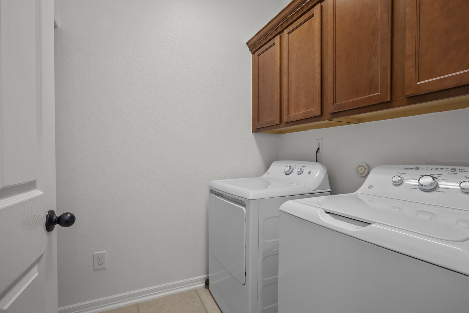 245 Razzmatazz Trail Buda, TX 78610 - Photo 32 of 37 Utility room featuring warm-toned wood cabinetry and neutral wall paint