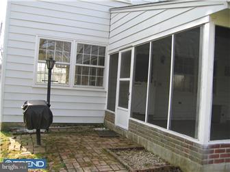 505 Scott Road Oreland, PA 19075 - Photo 4 of 10 a porch with a chair and potted plant in front of door