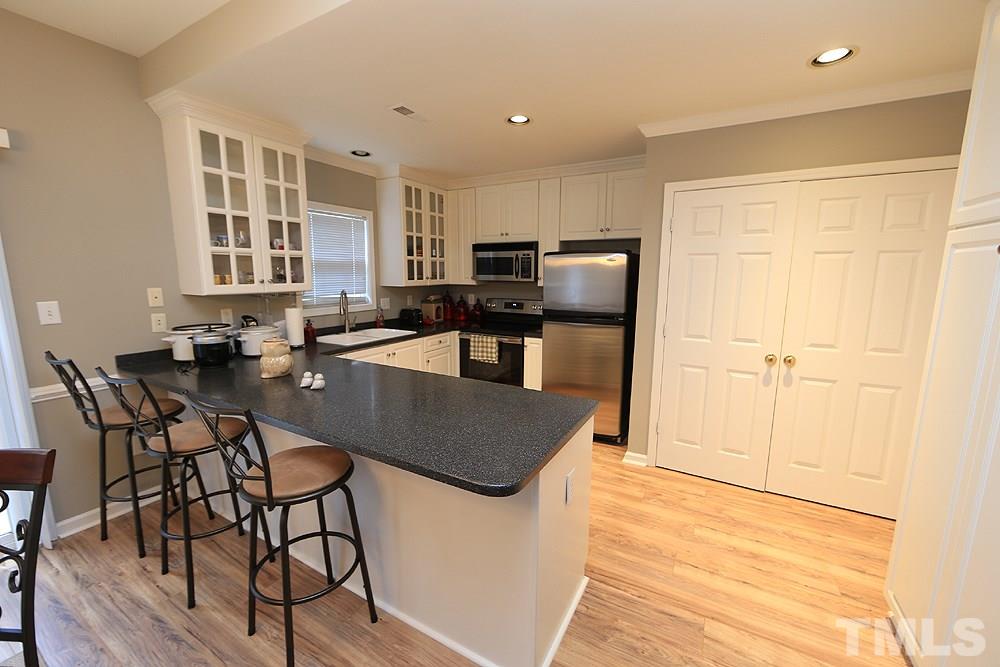 2011 Rivergate Road, Unit 101 Raleigh, NC 27614 - Photo 3 of 12 a kitchen with stainless steel appliances granite countertop a stove a sink a microwave and a refrigerator