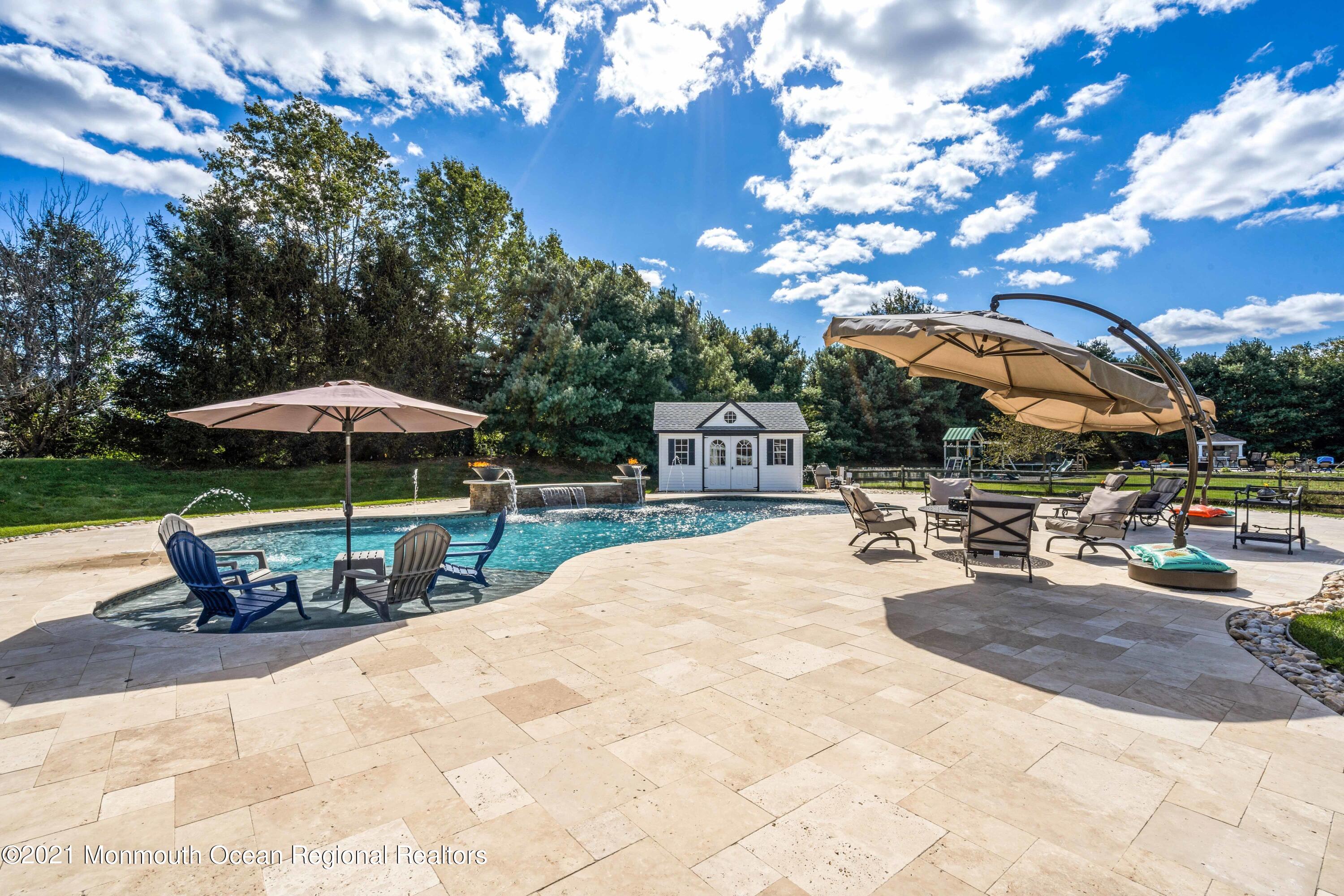 5 Michael Drive Cream Ridge, NJ 08514 - Photo 37 of 69 a view of a swimming pool with a table and chairs under an umbrella