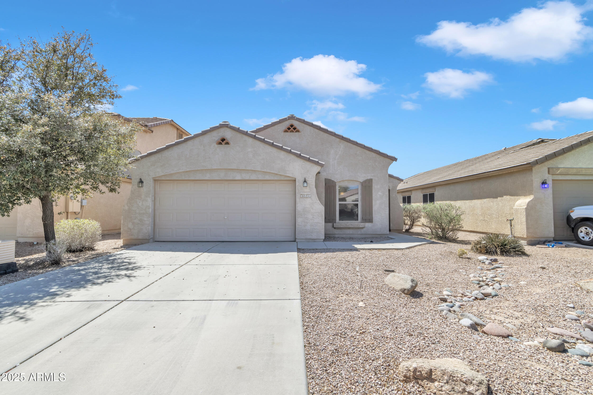 43849 West Cowpath Road Maricopa, AZ 85138 - Photo 4 of 42 a front view of a house with a dirt yard and garage