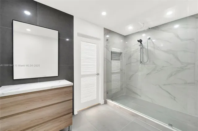 a bathroom with a shower a sink and a mirror