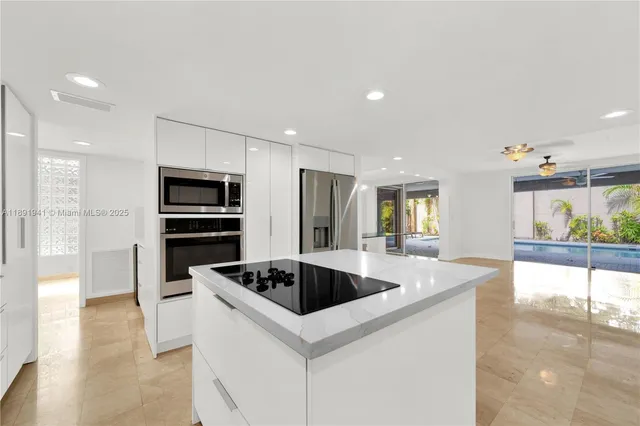 a kitchen with stainless steel appliances kitchen island a table and chairs