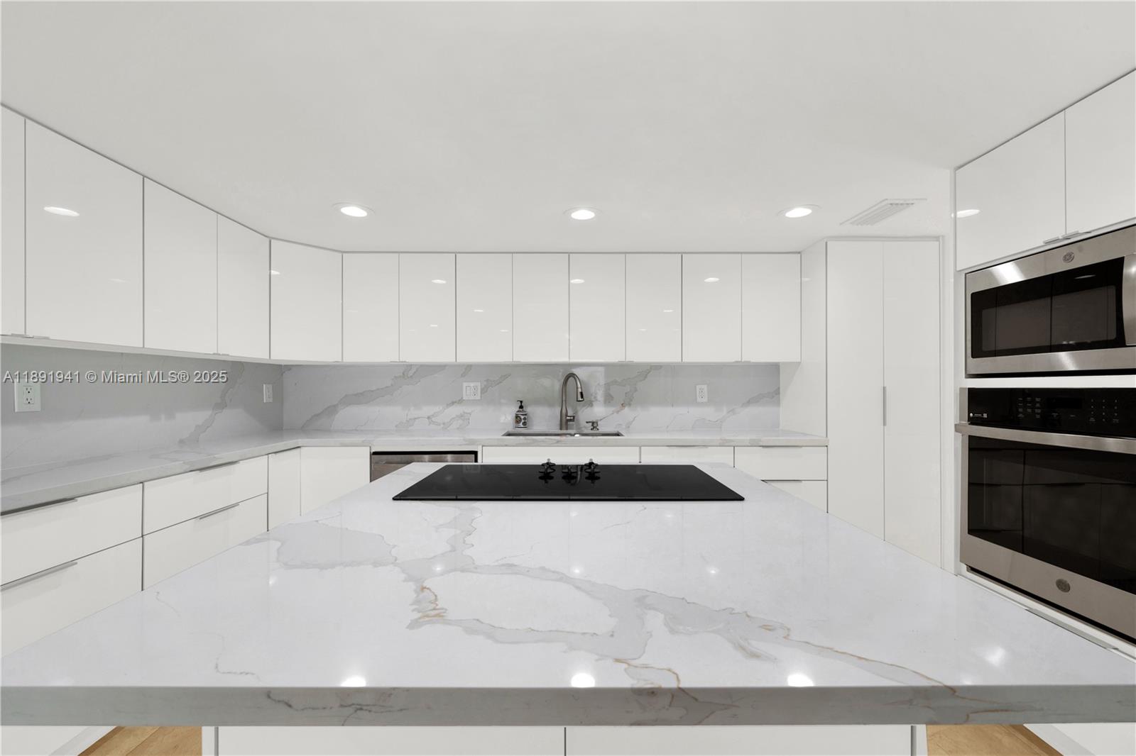 1769 Wa Kee Na Drive Miami, FL 33133 - Photo 4 of 21 a kitchen with granite countertop a sink and a stove top oven with white cabinets