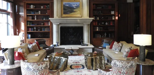 a living room with furniture a fireplace and bookshelf