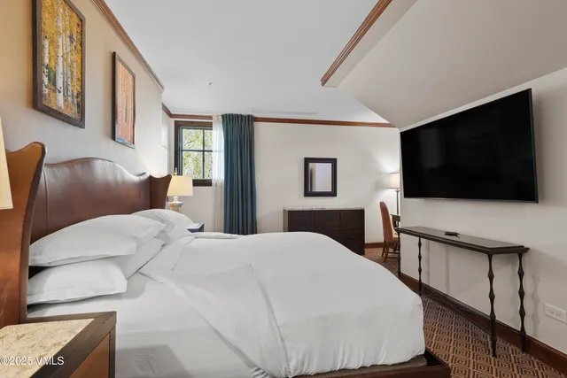 a bedroom with a bed and a flat screen tv